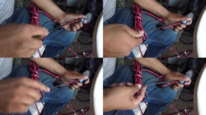 4k视频选择性聚焦中等镜头的男人用螺丝刀制作带扬声器连接器的音频扬声器电缆。技术人员手工制作声音扬声