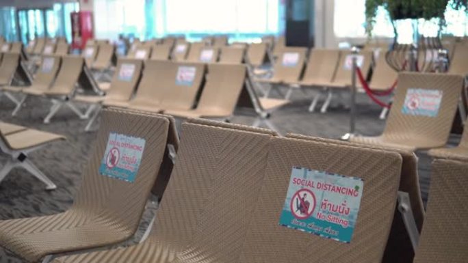 空荡荡的机场候机室，椅子上有社交距离标志