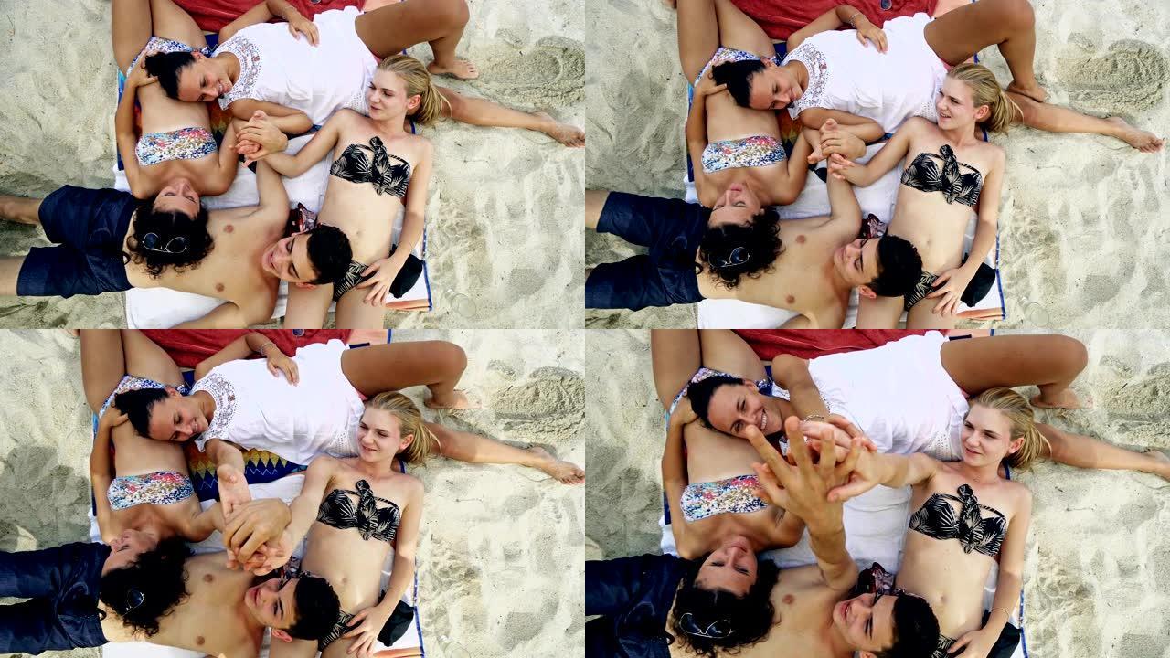 一群朋友在晴天躺在沙滩上。关于混血朋友和假期的概念