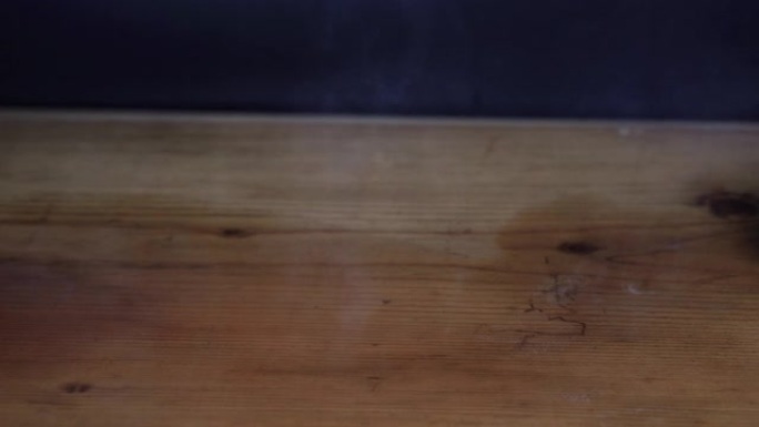 一杯咖啡洒在黑色背景的木桌上。