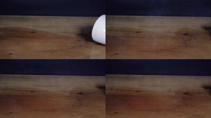 一杯咖啡洒在黑色背景的木桌上。