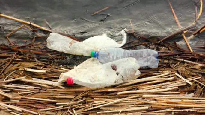 河岸上的塑料垃圾和塑料袋漂浮在水面上。封闭链的污染。不负责任地处理垃圾