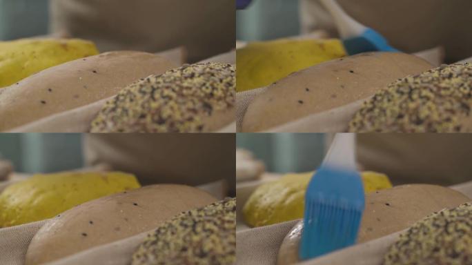 专家厨师使用烹饪涂抹刷给面包面团上油的特写演示。专业面包店概念