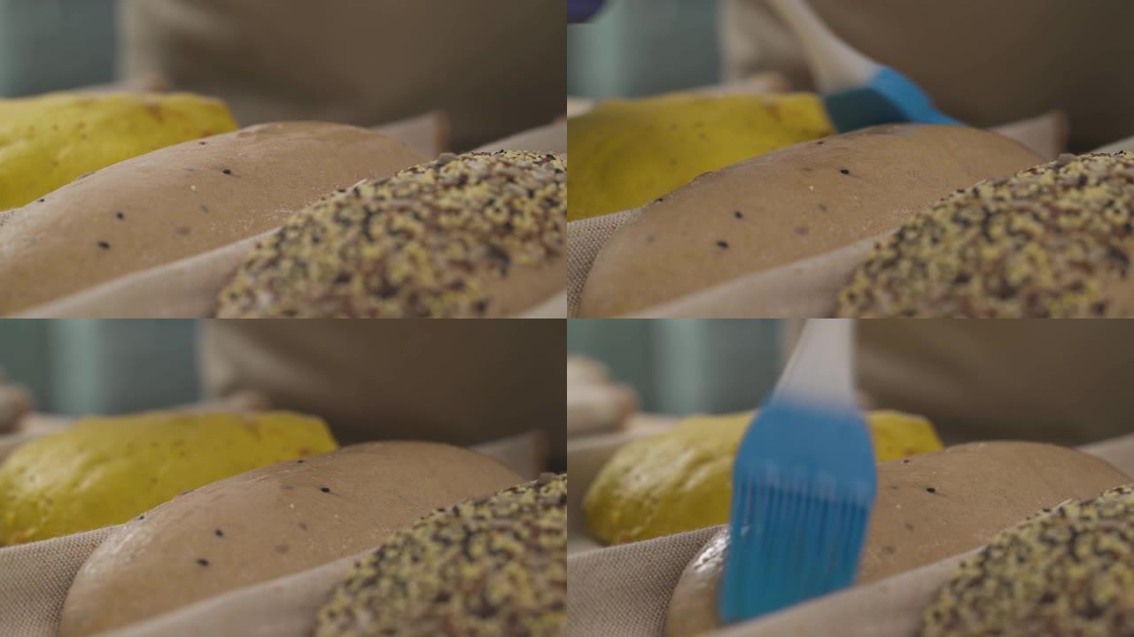 专家厨师使用烹饪涂抹刷给面包面团上油的特写演示。专业面包店概念