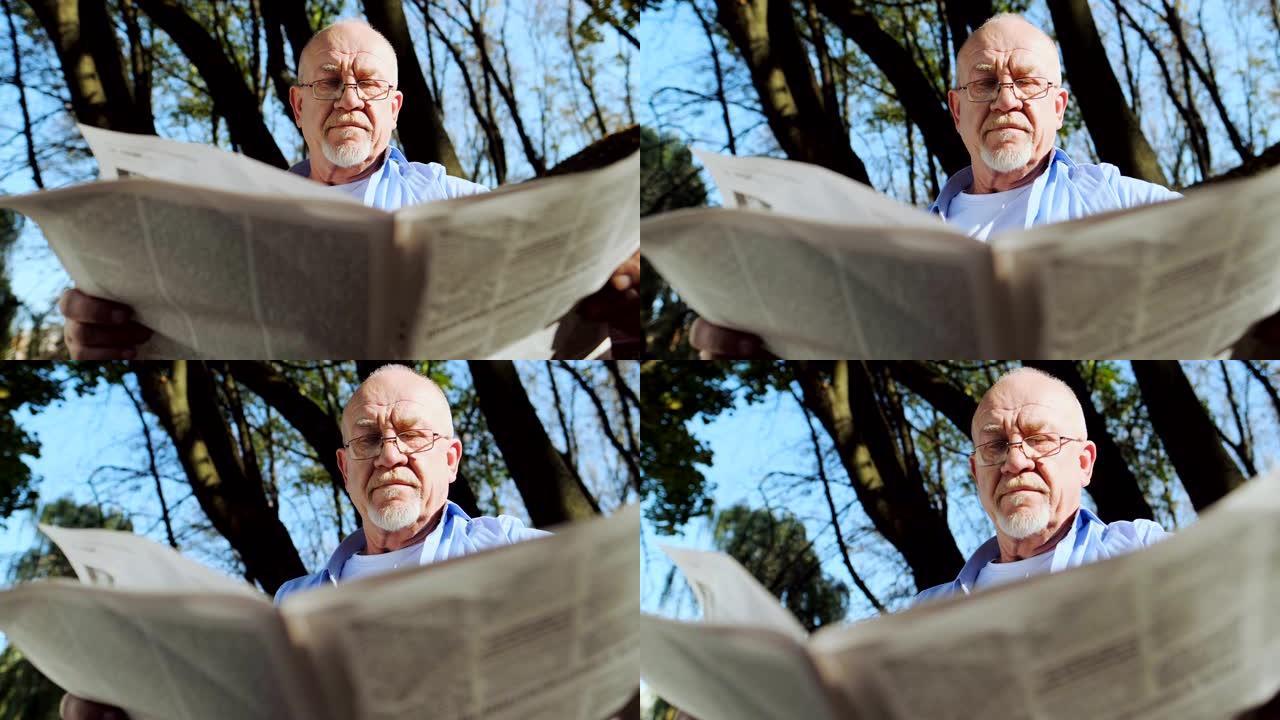 积极退休，老人留着胡须，戴着眼镜在公园里看报纸。