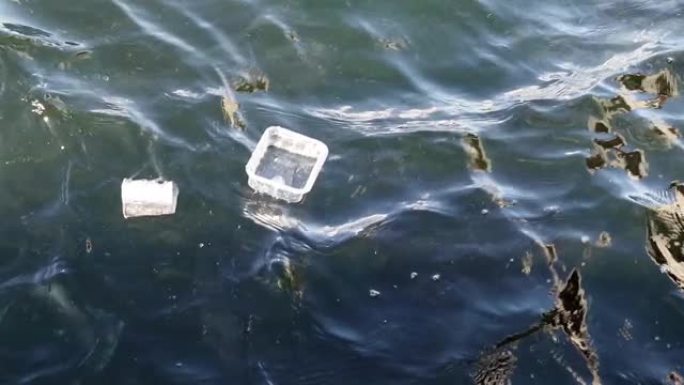一次性塑料器皿漂浮在海浪上。