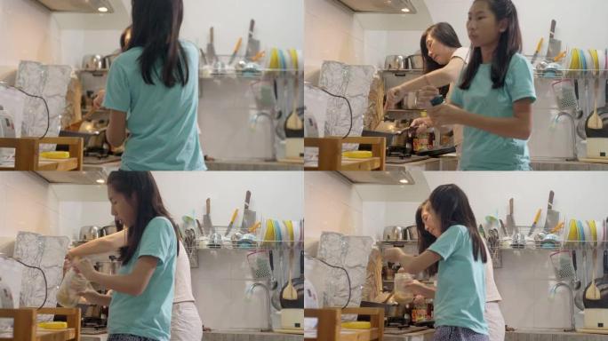 亚洲女孩自己学习烹饪食物，她的母亲有时总是支持和帮助生活方式。