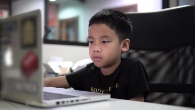 男孩学习视频在线课在隔离新型冠状病毒肺炎的家庭。