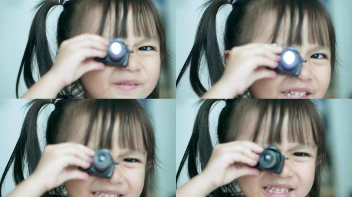 泰国可爱女婴在镜子前玩相机玩具的慢动作，微笑着带着积极的情绪大笑