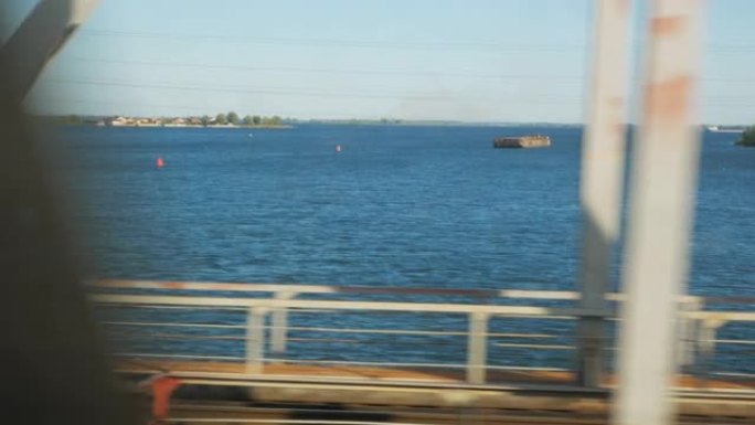 在一条宽阔的河上经过一座巨型桥。伏尔加河。从火车窗口观看