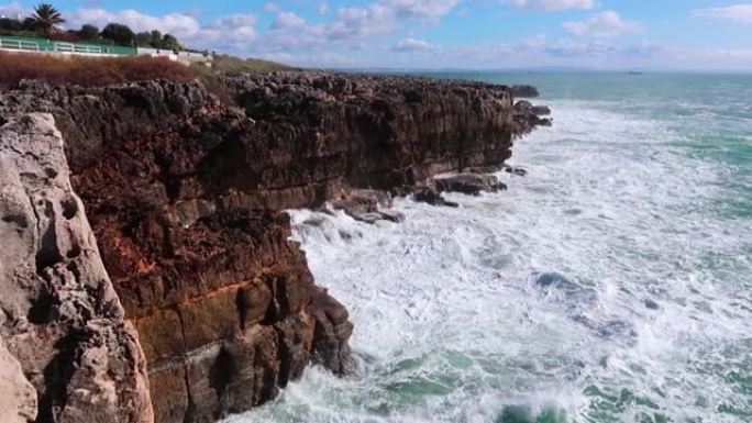 在晴朗的天气里，强大的海浪撞击岩石。纯粹的力量，自然力量的展示。强能量。对抗地球的海洋力量。