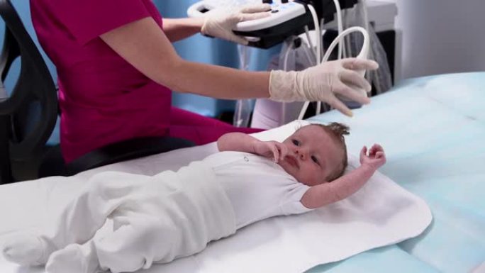 一名女医生在诊所使用现代医疗设备对新生婴儿的头部和大脑进行超声检查。儿科与儿童身体发育的控制