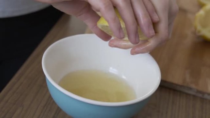 在碗里从柠檬中榨汁。