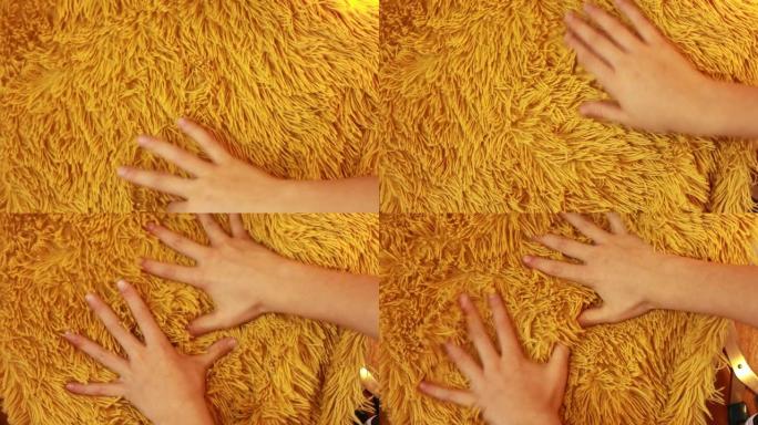 幼儿或妇女的手触摸黄色长堆人造毛皮非常舒适