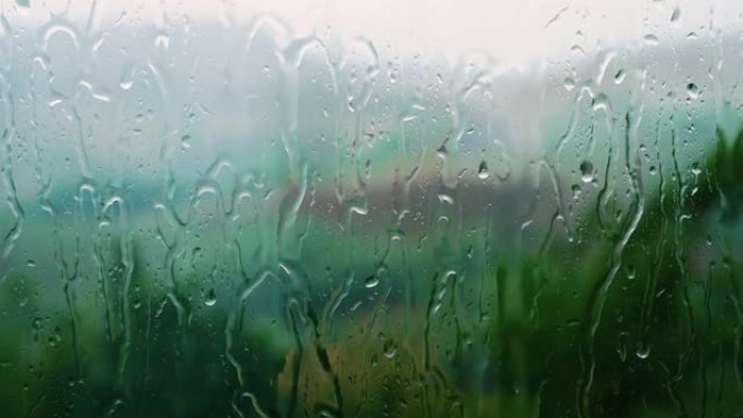 水滴从窗户流下，雨水，倾盆大雨流过窗户，美丽的纹理从水中，雷雨视频壁纸，特写。