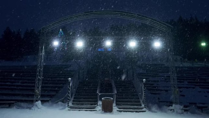 舞台灯光和雪。大雪期间室外舞台灯工作和发光