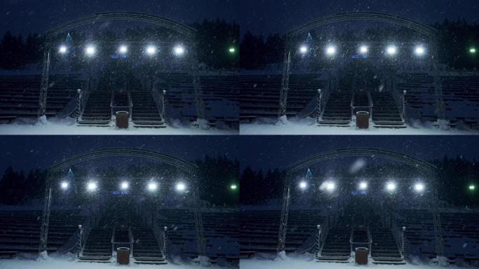 舞台灯光和雪。大雪期间室外舞台灯工作和发光