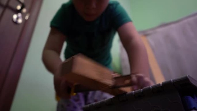 一个孩子正在用钢锯锯木板。