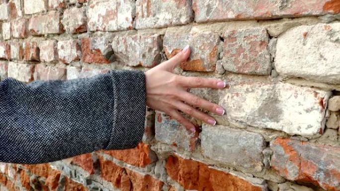 4k女人的手在旧砖墙上移动。滑行。感性的触摸。坚硬的石头表面。