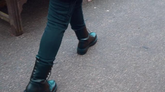 一个年轻的女孩穿着机车靴子，穿着4k的冬鞋。