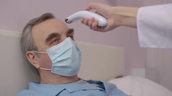 悲伤生病的老人在家里隔离，戴着手工制作的病毒保护面具。