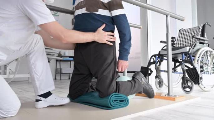 物理治疗师帮助坐轮椅的老人在康复中心锻炼。高质量4k镜头