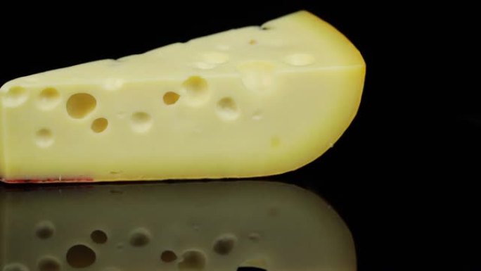 一块硬奶酪旋转成圆形，黑色背景和文本空间