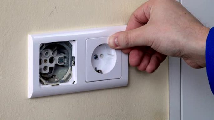 用螺丝刀关闭手在墙上安装电源插座