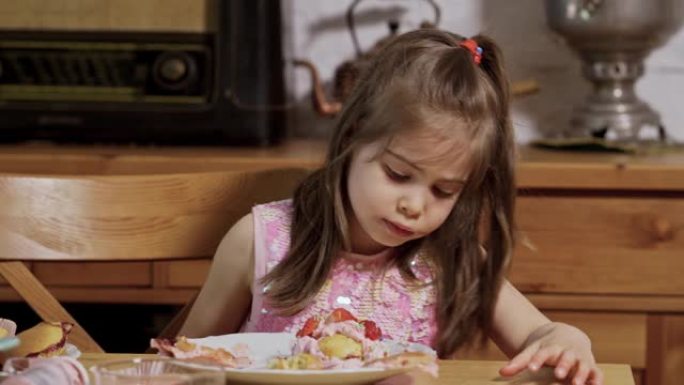 小女孩装饰和吃美味的纸杯蛋糕