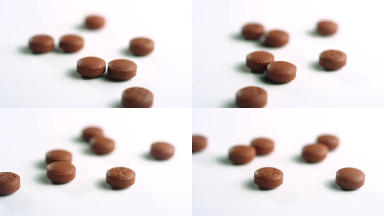 散开的棕色布洛芬药丸的特写镜头，在白色表面上的焦点直接旋转