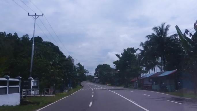 印度尼西亚巴厘岛路边卖食物的街头小贩 路中间有一座清真寺 一个男人站在栅栏前，上面挂着衣服