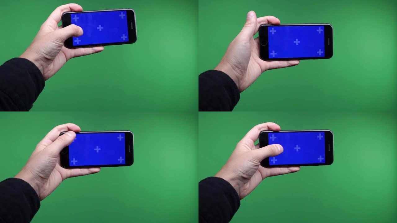 俄罗斯。莫斯科。2019。手机在手中近距离隔离在绿色背景。手机屏幕为蓝色色度键，背景色度键为绿色屏幕
