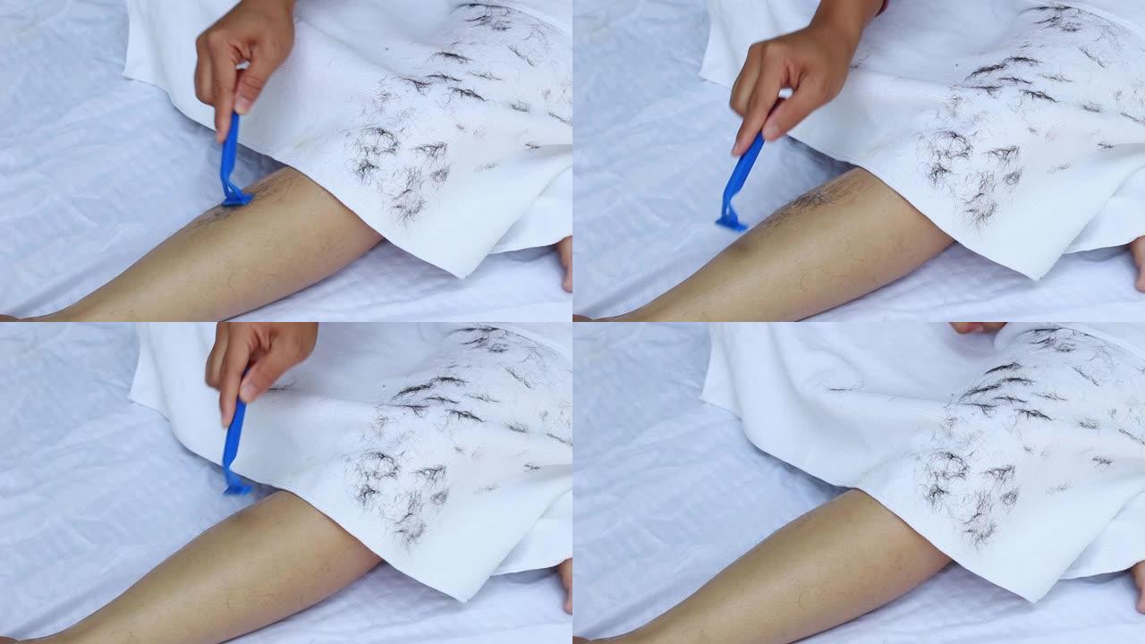 亚洲女性剃刀剃腿的特写镜头。身体护理和脱毛概念。