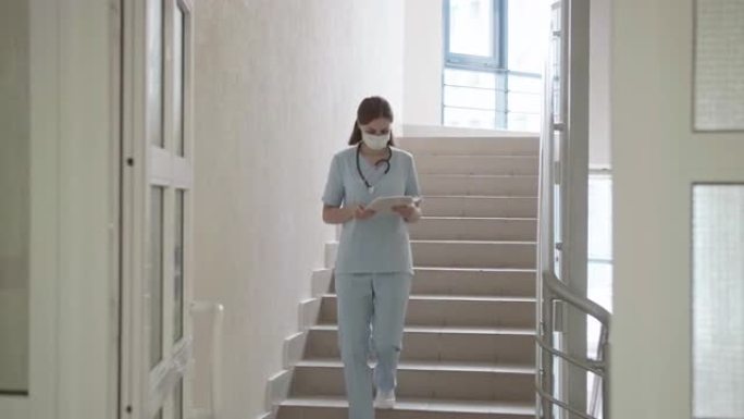 戴面具的医生走在医院的楼梯上