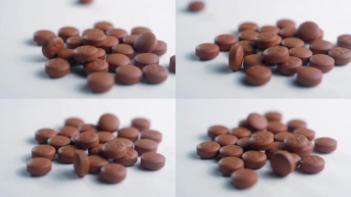 一堆棕色布洛芬药丸的特写镜头，在白色表面上旋转