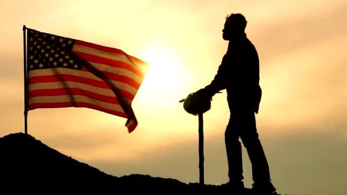 劳动节概念:举着鹤嘴锄的劳工站在美国国旗上