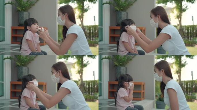 亚洲妈妈帮助女儿戴上保护面具，保护冠状病毒新型冠状病毒肺炎爆发情况，然后再上学。准备好学习概念。