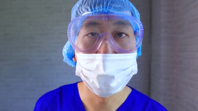 穿着ppe制服和口罩的亚洲男性医务人员在医院诊断和检查新型冠状病毒肺炎患者。年轻护士拿鼻拭子标本测试