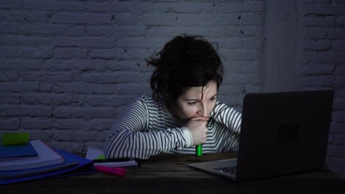 4k宽滑块视频，内容涉及过度劳累和疲倦的女学生在深夜在计算机笔记本电脑上工作时在桌子上入睡。在为期末