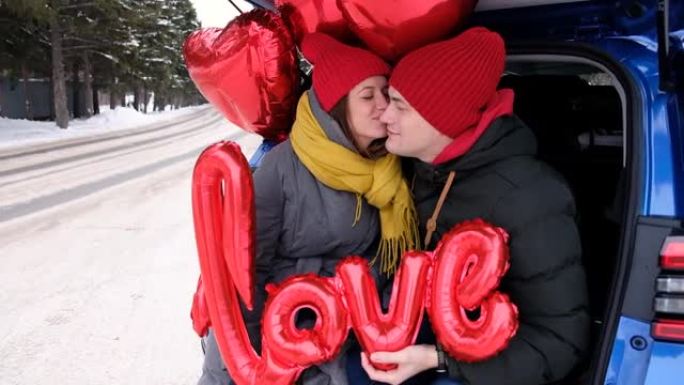 肖像幸福的夫妇的脸看着对方，笑着。红色心形气球和爱字。情人节庆典，浪漫关系，真诚的感情和爱情概念