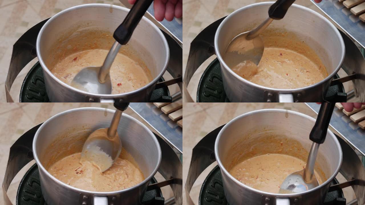 将泰国辣椒酱添加到沸腾的椰奶中。一步一步煮汤姆山药汤。泰国菜。特写。4k