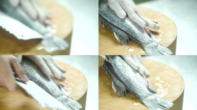 准备食物，厨师的手在厨房的木板上切片和切割新鲜的鲈鱼。