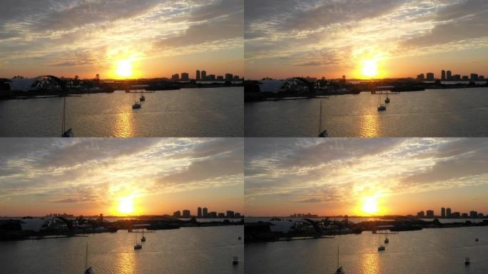 拉出迈阿密海岸附近色彩缤纷的日落，帆船和建筑物的空中拍摄