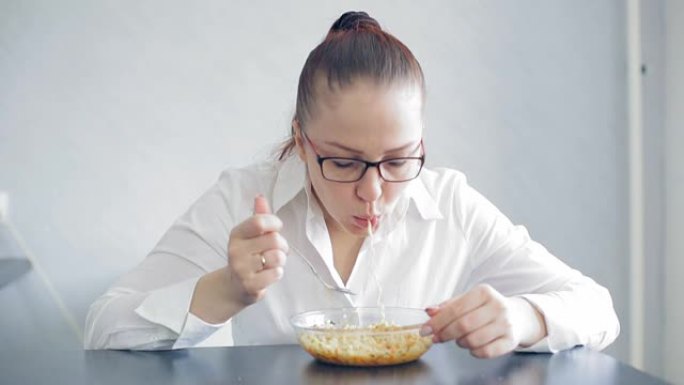 美丽的生活方式女人戴眼镜吃面