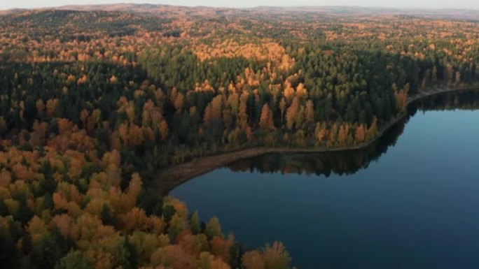 秋天五颜六色的森林中山岗附近的湖泊鸟瞰图