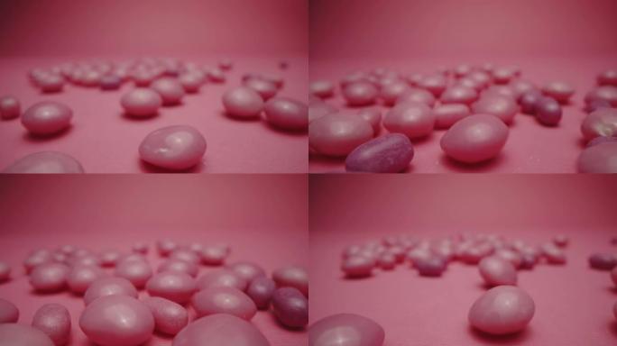 紫色和粉红色硬糖孤立在粉红色的背景