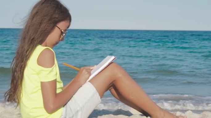 孩子在海滩上写日记。