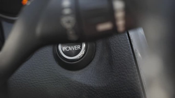 启动汽车发动机。手指按下按钮启动汽车发动机。