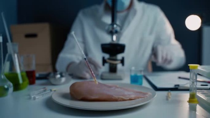 食品质量控制科学家在实验室与显微镜合作。生肉中含有抗生素的注射器，鸡肉中含有转基因生物的注射剂，食品