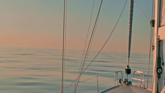 日落时，帆船在大西洋平静的宁静海水中鞠躬。帆和钻机的视图